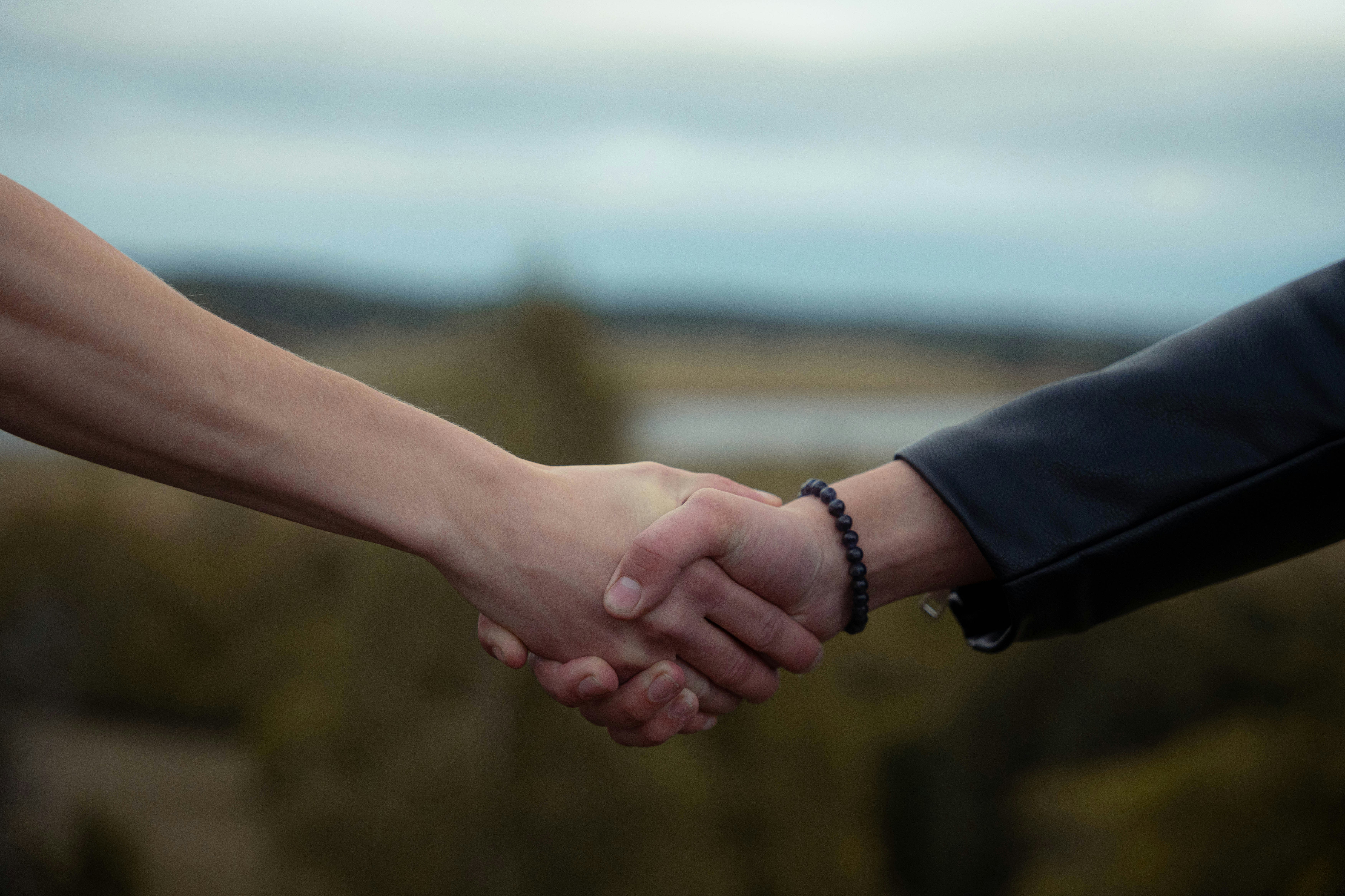Handshake in Front of Oil Rig